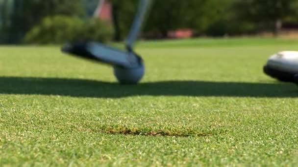 Detailní záběr golfista pomocí putter ponořit krátký putt do díry, — Stock video