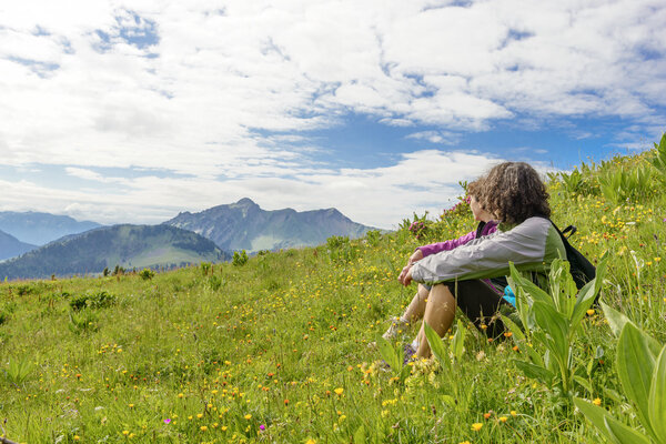 two women sitting in the grass and looking at the landscape