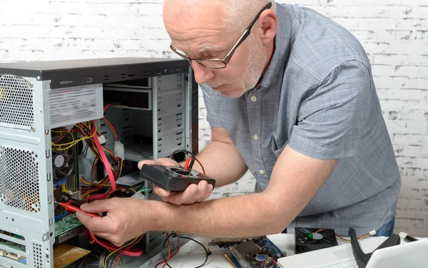 Um técnico que repara um computador — Fotografia de Stock