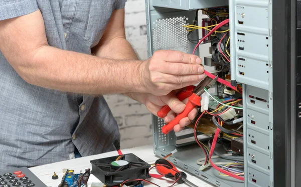 Um técnico que repara um computador — Fotografia de Stock