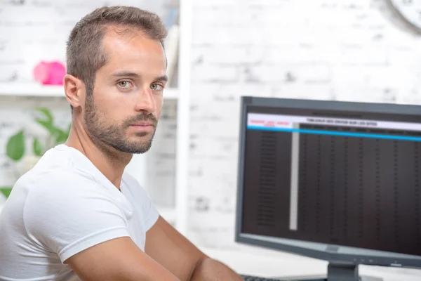 Jonge uitvoerende werken met zijn computer — Stockfoto