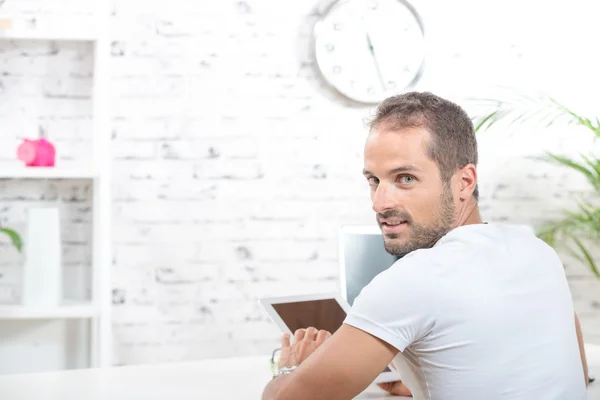 Een jonge man kijkend naar een tablet — Stockfoto