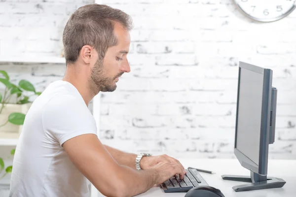 Jonge uitvoerende werken met zijn computer — Stockfoto