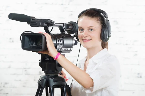 Une jolie jeune femme avec une caméra professionnelle — Photo