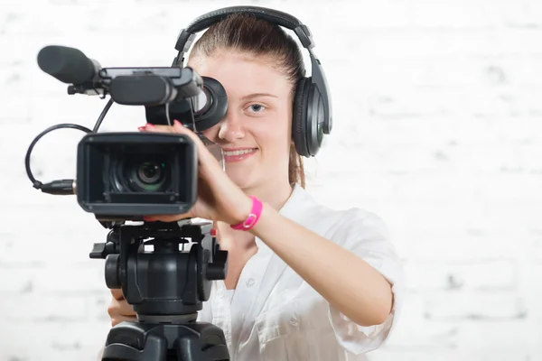 Une jolie jeune femme avec une caméra professionnelle — Photo