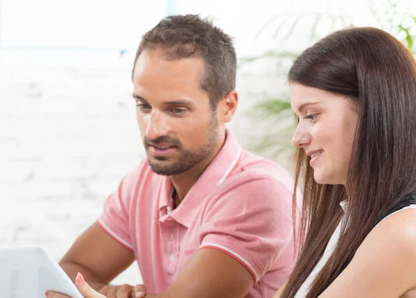 A young couple looking at a tablet — Stock Photo, Image
