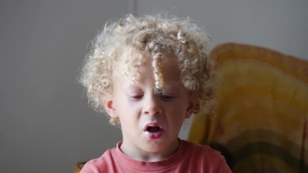 Un niño rubio comiendo un helado — Vídeo de stock