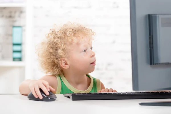 A little blond boy playing with  computer — Stock Photo, Image