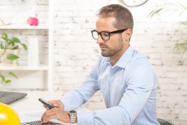 akıllı telefon ile ofisinde genç bir adam portresi