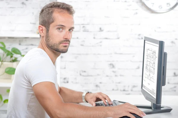 Jonge uitvoerende werken met zijn computer in zijn kantoor — Stockfoto