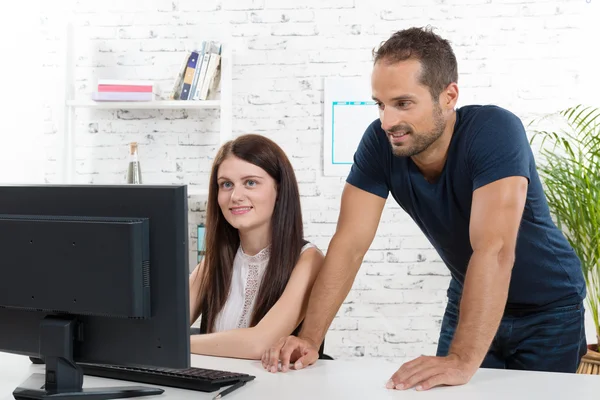 Um jovem executivo e seu secretário procurando computador — Fotografia de Stock