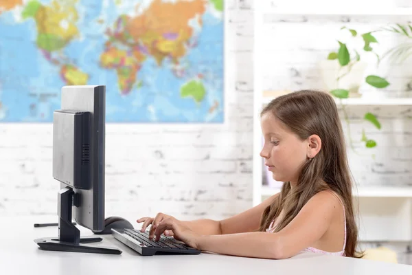 Een schoolmeisje werken op een computer in de klas — Stockfoto