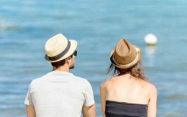 Couple, vue de derrière, assis près de l'eau — Photo
