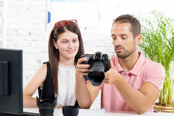 Una joven pareja mirando fotos en la cámara — Foto de Stock