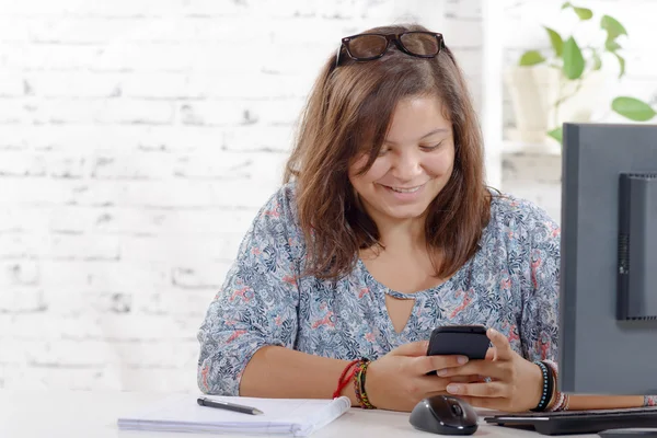 Een tienermeisje spelen met haar mobiele telefoon — Stockfoto