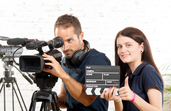 a cameraman and a young woman with a movie camera