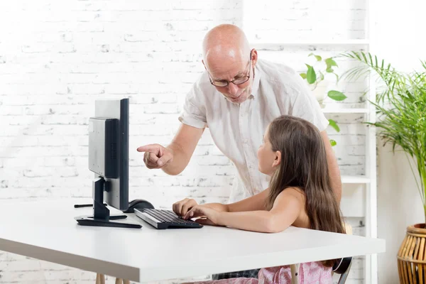 Učitelka pomáhá školačka v počítači — Stock fotografie