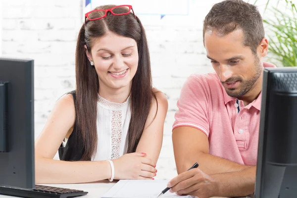 Couple at work in the office, man write — Stock fotografie