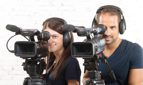 a man and a woman with professional video cameras