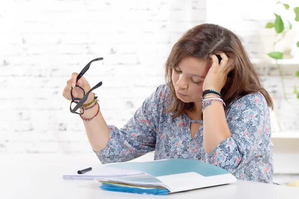 A teenage girl  with eyeglasses doing her homework — Stock Photo, Image