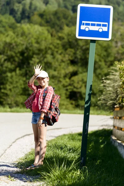 Scuola ragazza con cappello bianco, in attesa di autobus — Foto Stock