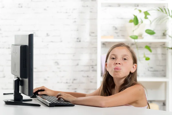 Una chica con muecas frente a una computadora —  Fotos de Stock