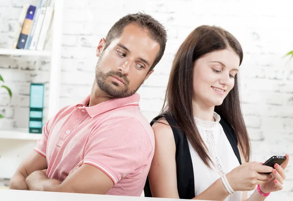 Jong koppel vergadering rug aan rug, vrouw telefoon — Stockfoto