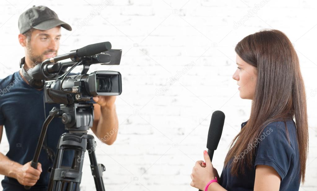 a young woman journalist with a microphone and a cameraman