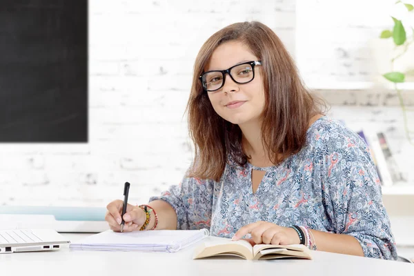 Een tienermeisje haar huiswerk in klas — Stockfoto