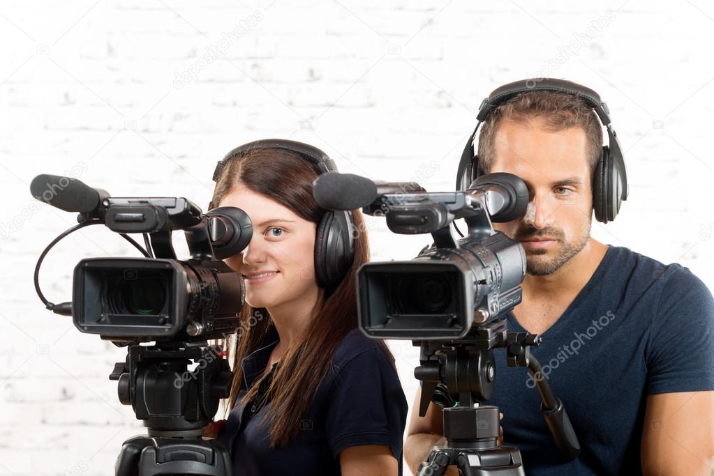 young man and woman with professional video cameras