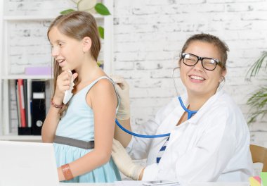 küçük bir kız genç bir doktor inceliyor