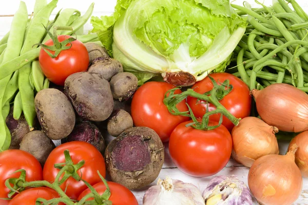 Diverse groenten op een witte houten tafel — Stockfoto