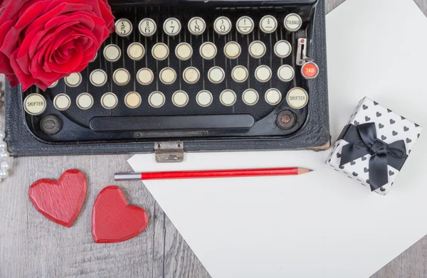 Vieille machine à écrire avec une rose rouge — Photo