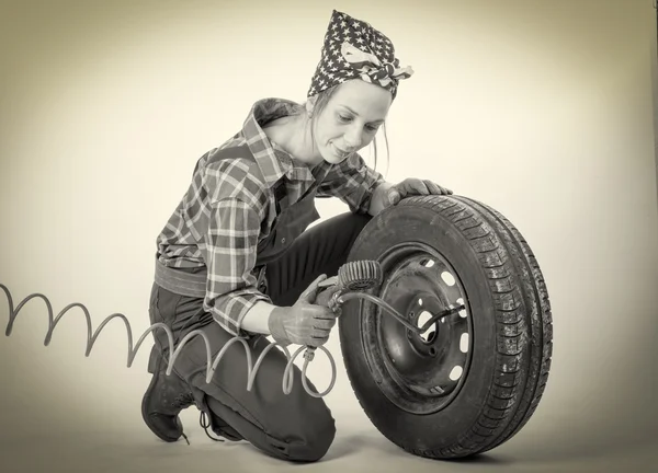 Black and white vintage and young woman inflates a car tire — Stock Photo, Image