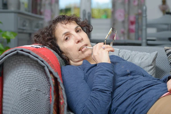 Una mujer enferma durmiendo en un sofá en su casa —  Fotos de Stock
