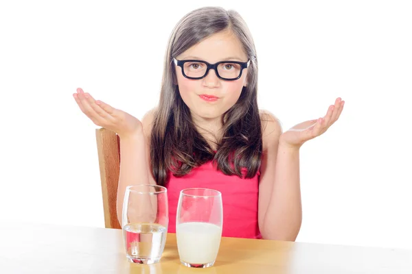 Una niña tiene una opción entre un vaso de agua y un vaso —  Fotos de Stock
