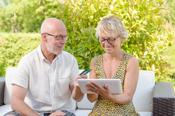 Senior couple using tablet to make a purchase — Stock Photo, Image