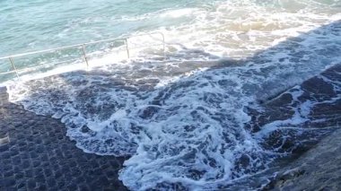 Okyanus dalgaları iskeleye çarpıyor.