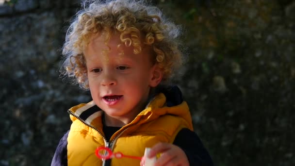 Kleiner Junge pustet Blasen in Zeitlupe — Stockvideo