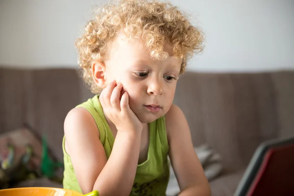 Young blonde child looks a tablet — Stock Photo, Image