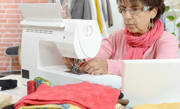 Dressmaker mujer trabajando con máquina de coser — Foto de Stock