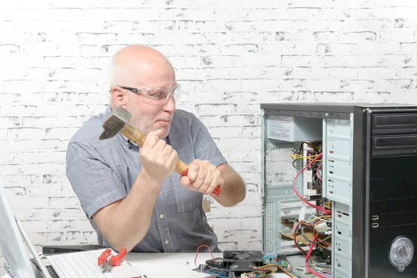 Muž udeřil kladivem na počítači — Stock fotografie
