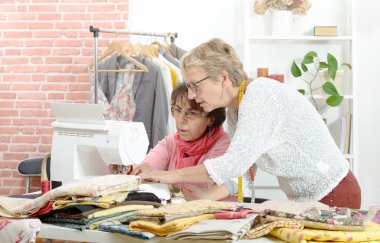 Birlikte kendi atölyesinde çalışan iki neşeli seamstresses