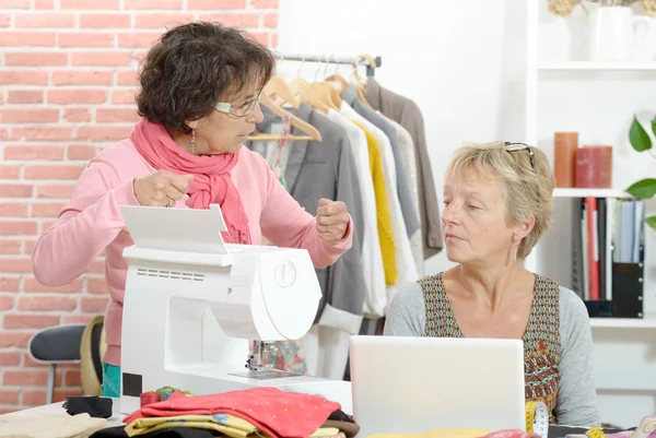 Zwei gut gelaunte Näherinnen arbeiten in ihrer Werkstatt zusammen — Stockfoto