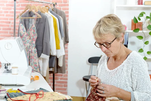 Mujer de mediana edad que trabaja en el taller de costura —  Fotos de Stock