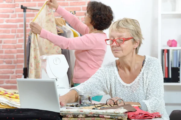 Dos costureras alegres trabajando juntas en su taller — Foto de Stock