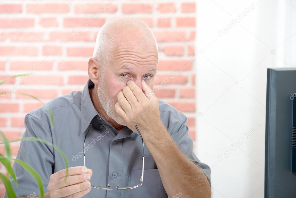 Office worker with eye pain touching his eyes