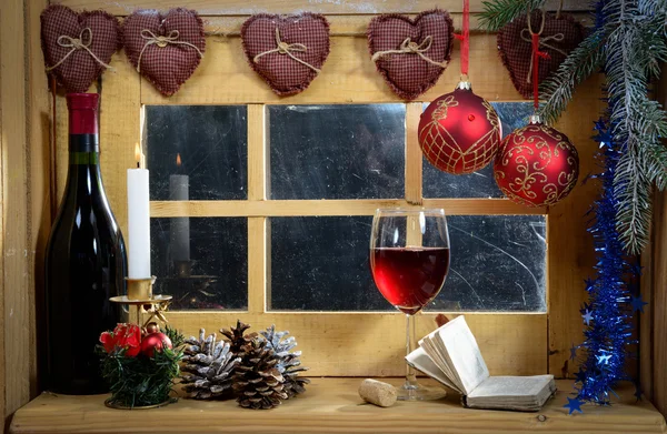 Glass of wine at the window, with a christmas decoration — Stock Photo, Image