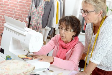 Birlikte kendi atölyesinde çalışan iki neşeli seamstresses