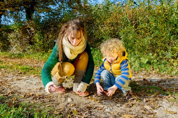 Un petit garçon blond et sa mère jouent dehors — Photo